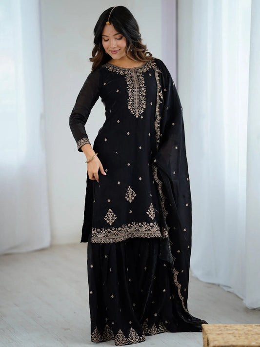 Schwarzes Sharara-Set aus Seide mit goldener Zari-Stickerei, bestehend aus Top, weiter Sharara-Hose und Dupatta – festliche indische Damenmode.